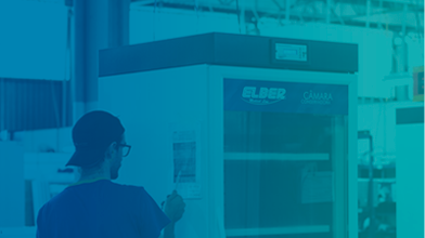 Rapaz próximo a câmara de conservação consultando as informações coladas na lateral da câmara