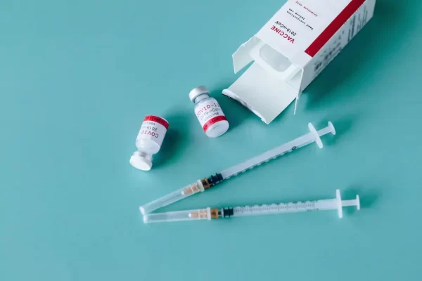 Frascos de vacina e seringas destacando a biossegurança em laboratório.